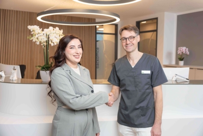 Dr. Dr. Santo begrüßt eine Patientin im Empfang der Praxisklinik