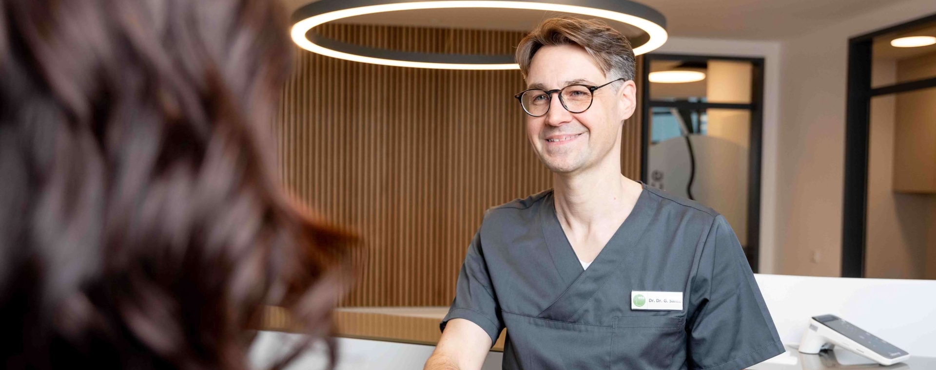 Dr. Dr. Santo verabschiedet mit Händeschütteln eine Patientin